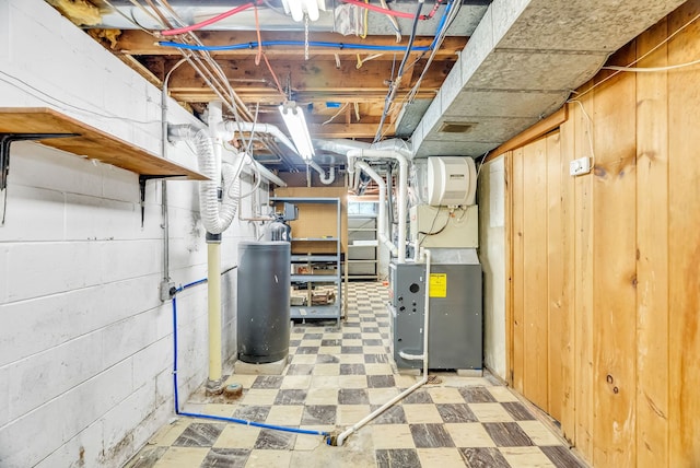 unfinished below grade area with tile patterned floors, heating unit, and wooden walls