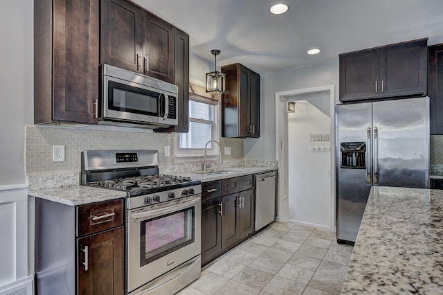 kitchen featuring stainless steel appliances, a sink, dark brown cabinetry, tasteful backsplash, and recessed lighting