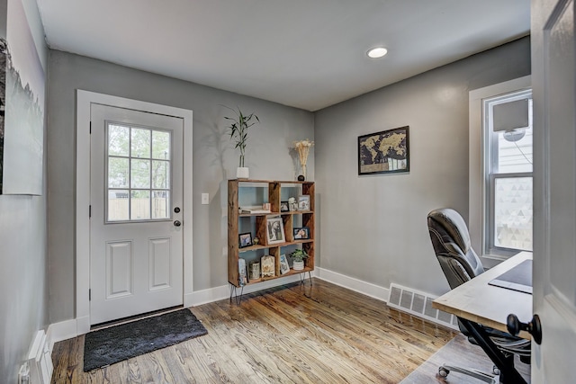 office area featuring a baseboard heating unit, baseboards, wood finished floors, and recessed lighting