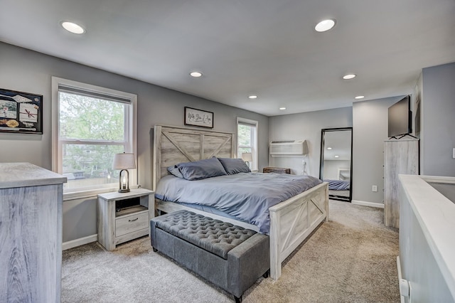 bedroom featuring light colored carpet, recessed lighting, baseboards, and a wall unit AC