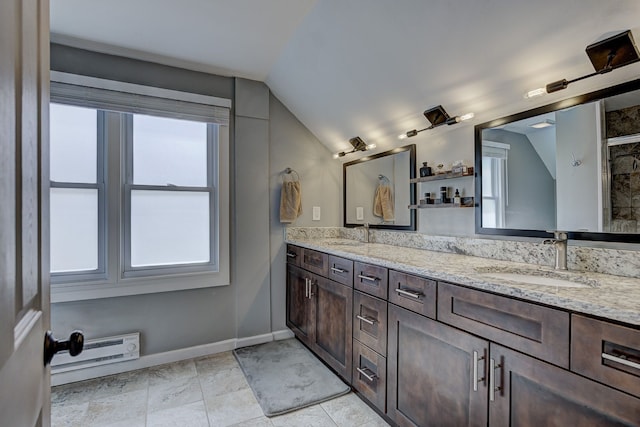 bathroom with vaulted ceiling, double vanity, baseboards, and a baseboard radiator