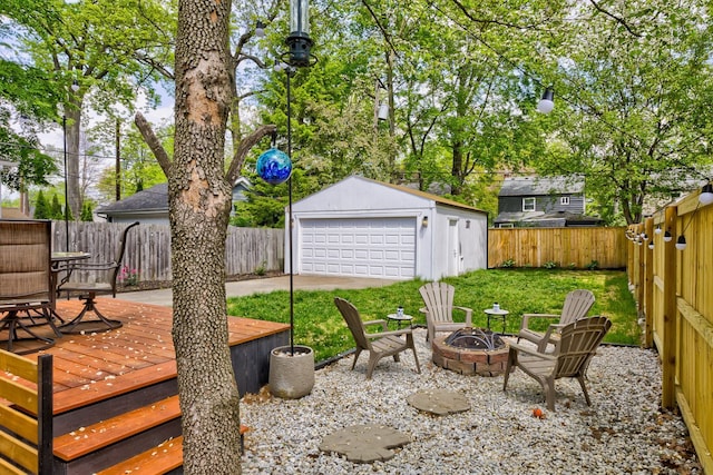 view of patio / terrace with a fire pit, a detached garage, a wooden deck, and an outdoor structure