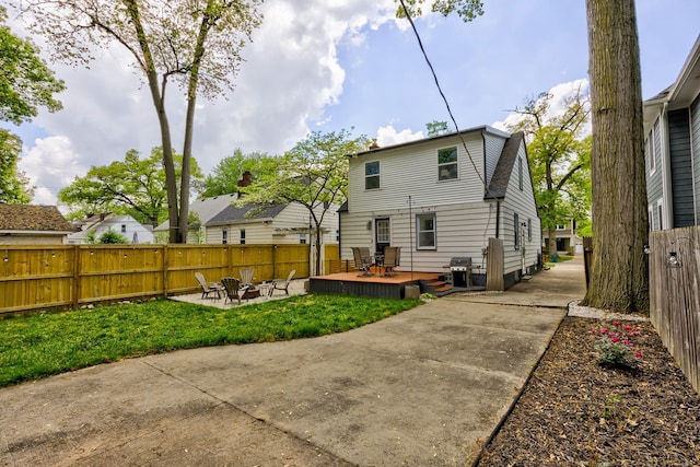 back of property featuring an outdoor fire pit and a wooden deck