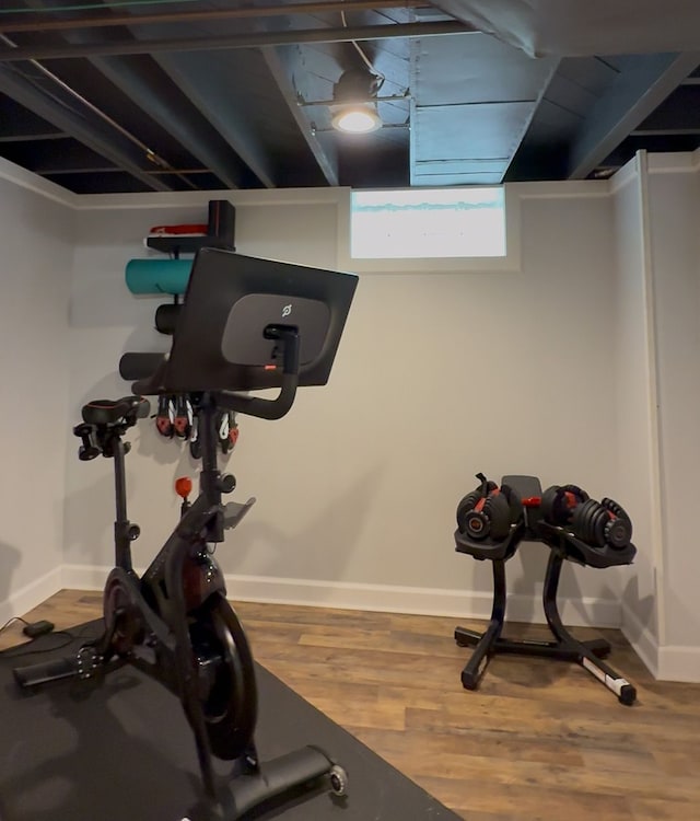 workout area featuring wood finished floors and baseboards