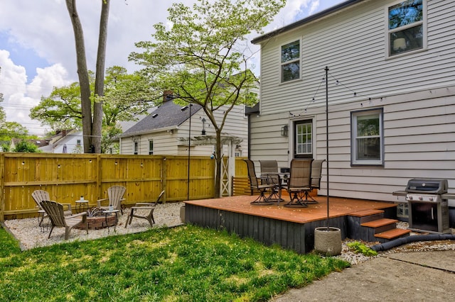 rear view of house with a deck and a fire pit