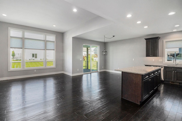 kitchen featuring a sink, dark wood finished floors, open floor plan, baseboards, and recessed lighting