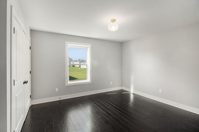 unfurnished bedroom featuring baseboards and dark wood-style flooring