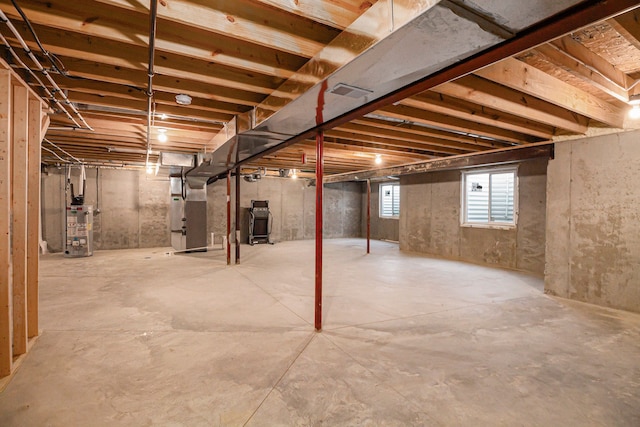 below grade area featuring water heater and heating unit