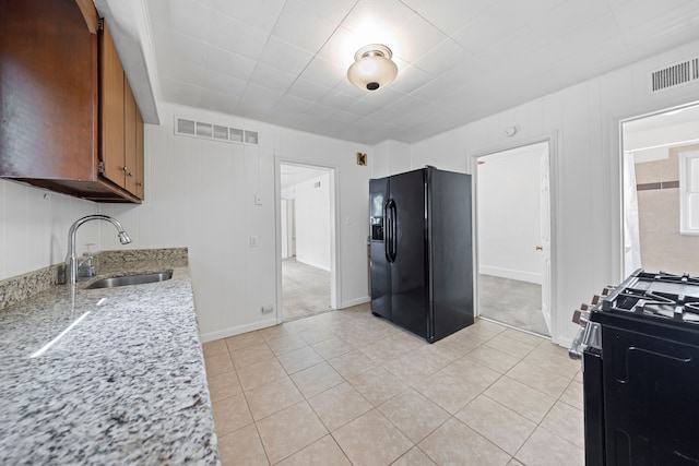 842 E 10 Mile Rd, Ferndale, MI 48220 - kitchen with black appliances, a sink, light tile patterned flooring, and brown cabinets