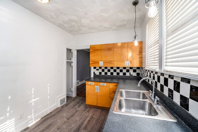22619 Santa Maria St, Detroit, MI 48219 - kitchen with a sink, decorative backsplash, dark wood-style floors, dark countertops, and brown cabinetry
