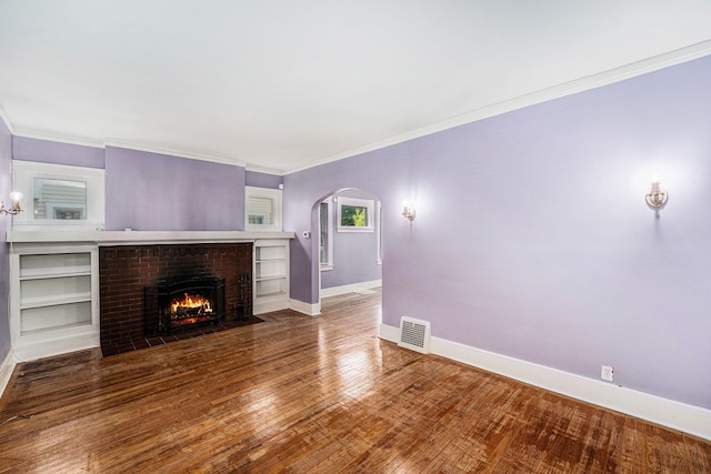 22619 Santa Maria St, Detroit, MI 48219 - unfurnished living room featuring arched walkways, baseboards, crown molding, a fireplace, and wood finished floors