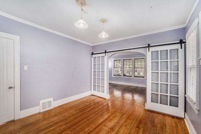 22619 Santa Maria St, Detroit, MI 48219 - spare room with a barn door, wood finished floors, baseboards, and ornamental molding