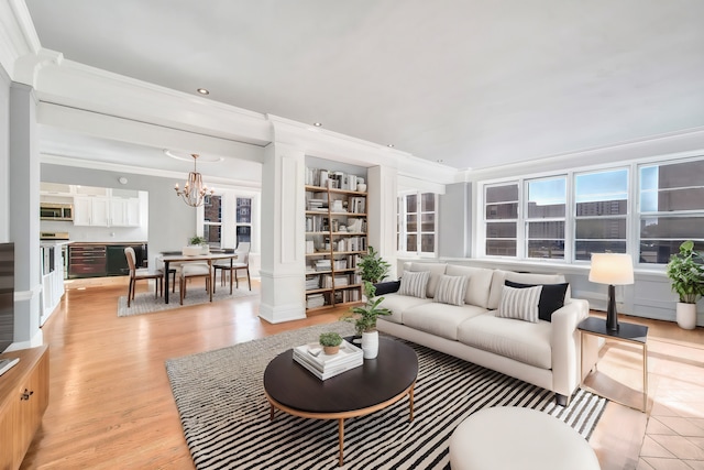 living area with ornamental molding, a chandelier, light wood-type flooring, and built in features