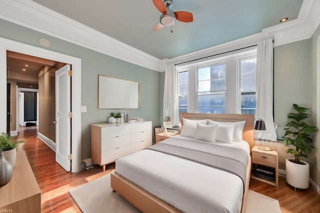 bedroom with crown molding, wood finished floors, baseboards, a ceiling fan, and recessed lighting