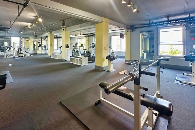 gym with rail lighting and baseboards