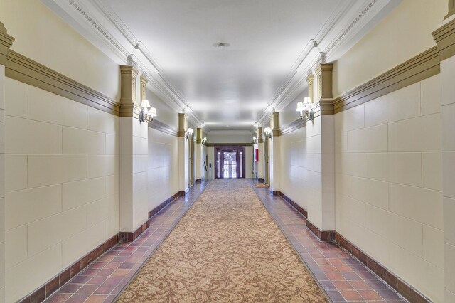 hall featuring crown molding and dark tile patterned flooring
