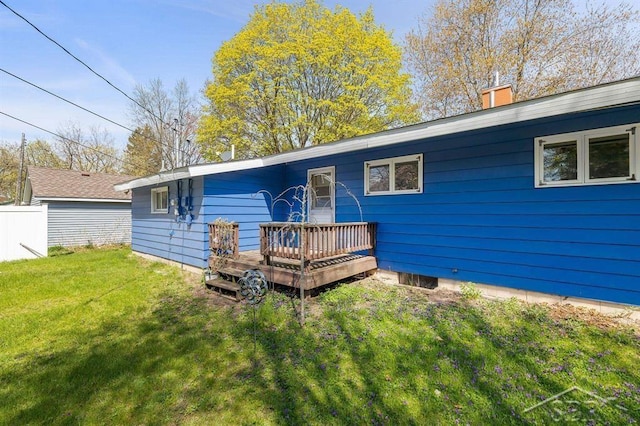 301 W Fourth St, Gladwin, MI 48624 - back of house featuring a wooden deck, a yard, and a chimney