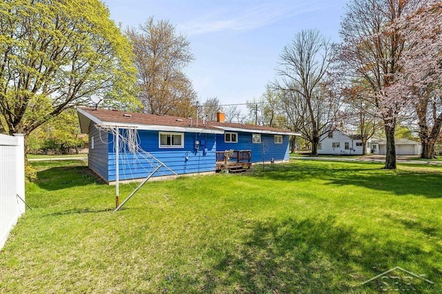 301 W Fourth St, Gladwin, MI 48624 - back of property with a yard, a chimney, and a wooden deck