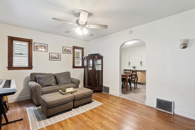 1430 New York Ave, Lansing, MI 48906 - living room featuring arched walkways, ceiling fan, light wood-style flooring, and baseboards