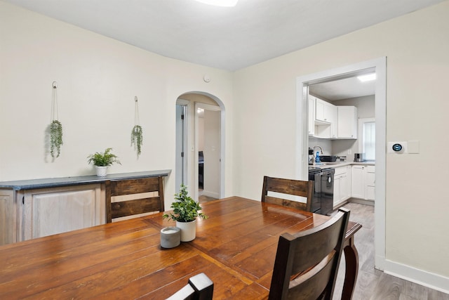 1430 New York Ave, Lansing, MI 48906 - dining area featuring arched walkways, light wood finished floors, and baseboards