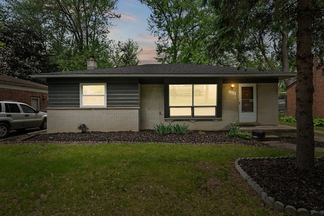 9319 Merriman Rd, Livonia, MI 48150 - view of front of house featuring brick siding, a yard, and a chimney
