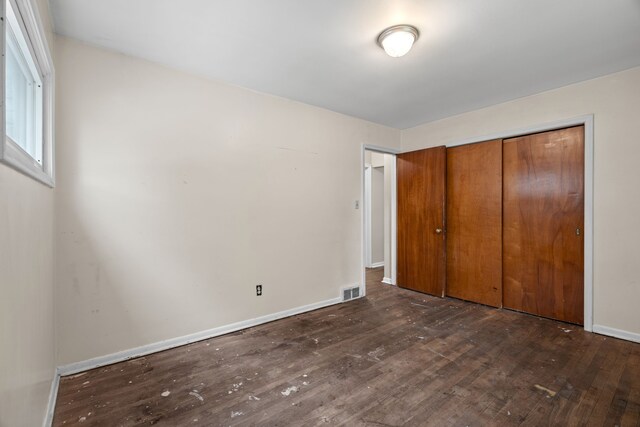9319 Merriman Rd, Livonia, MI 48150 - unfurnished bedroom with dark wood-type flooring, a closet, and baseboards