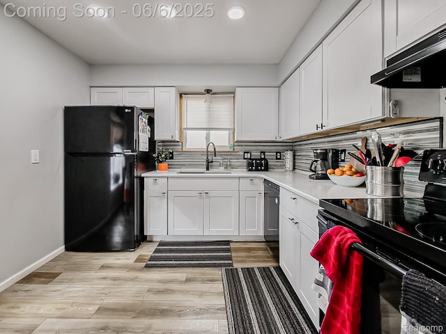 13327 Murthum Ave, Warren, MI 48088 - kitchen featuring black appliances, ventilation hood, a sink, light countertops, and white cabinetry