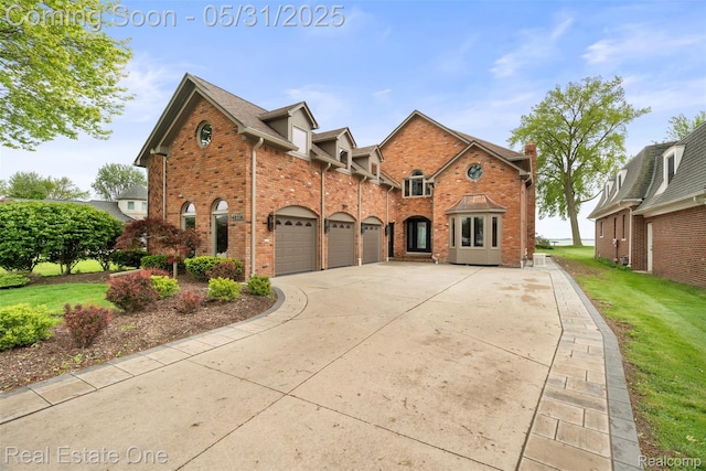 48556 Harbor Dr, Chesterfield, MI 48047 - view of front of home with concrete driveway, brick siding, a front lawn, and an attached garage