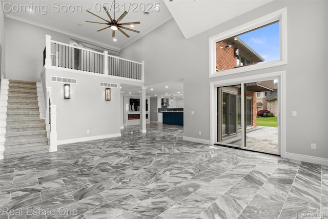 48556 Harbor Dr, Chesterfield, MI 48047 - unfurnished living room with marble look tile flooring, a high ceiling, baseboards, ornamental molding, and plenty of natural light