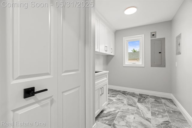 48556 Harbor Dr, Chesterfield, MI 48047 - laundry area featuring electric panel, baseboards, light marble finish flooring, and cabinet space
