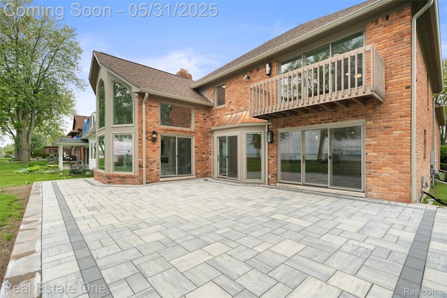 48556 Harbor Dr, Chesterfield, MI 48047 - back of house featuring a balcony, brick siding, and a patio area