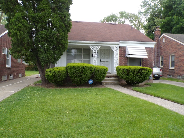 9546 Westwood St, Detroit, MI 48228 - bungalow-style house featuring a front yard, roof with shingles, and brick siding