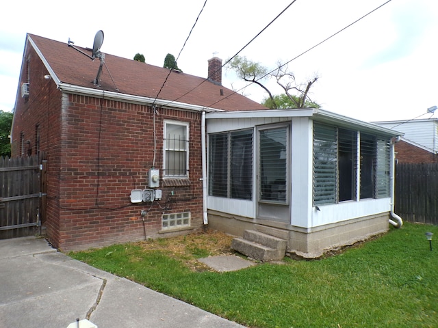 9546 Westwood St, Detroit, MI 48228 - view of side of property with a sunroom, a chimney, and brick siding