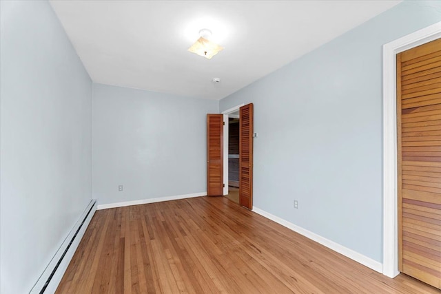30617 Young Dr, Gibraltar, MI 48173 - unfurnished bedroom featuring a baseboard heating unit, light wood-type flooring, and baseboards