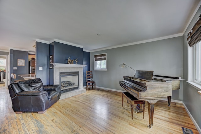 2230 Princeton Rd, Berkley, MI 48072 - living room with wood finished floors, a tiled fireplace, baseboards, and crown molding