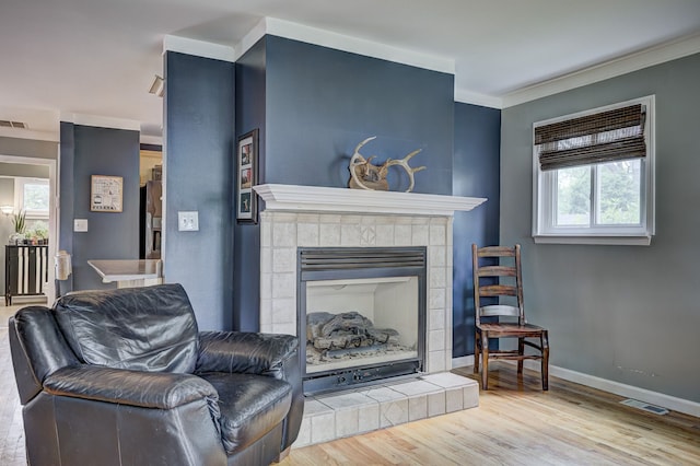 2230 Princeton Rd, Berkley, MI 48072 - living area featuring wood finished floors, a tiled fireplace, baseboards, and ornamental molding