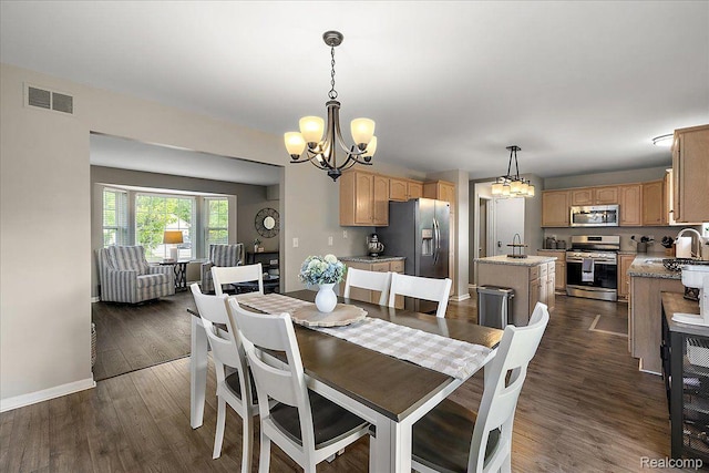457 Cove View Dr, Waterford, MI 48327 - dining area featuring a chandelier, dark wood-style flooring, and baseboards