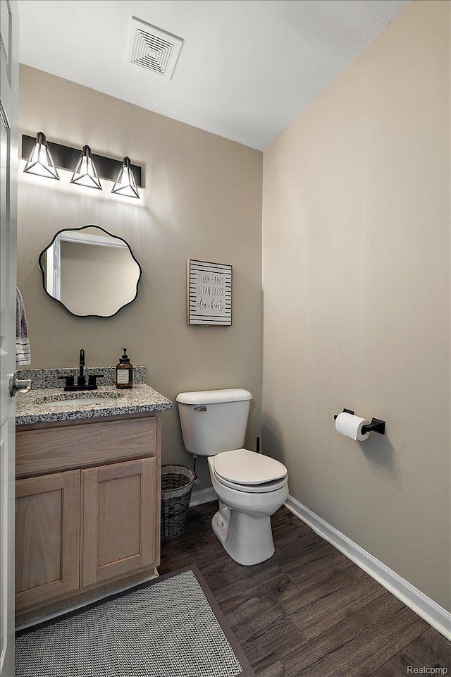 457 Cove View Dr, Waterford, MI 48327 - half bath featuring baseboards, toilet, wood finished floors, and vanity