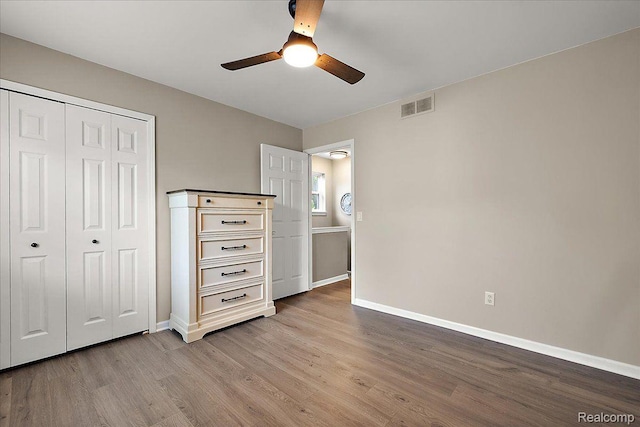 457 Cove View Dr, Waterford, MI 48327 - unfurnished bedroom featuring wood finished floors, baseboards, a closet, and a ceiling fan