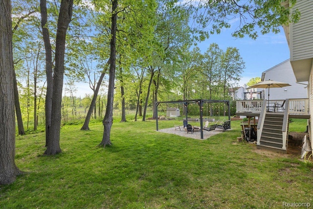 457 Cove View Dr, Waterford, MI 48327 - view of grassy yard featuring an outdoor fire pit, a deck, and stairs