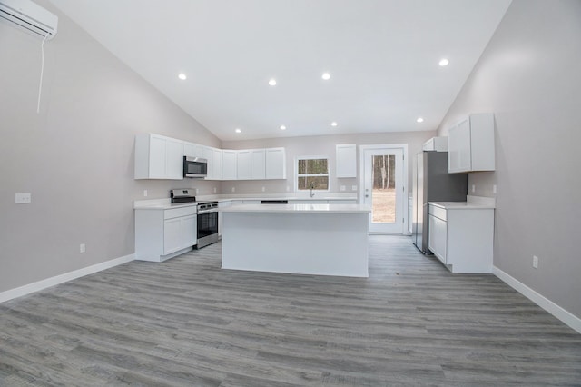 5203 NE Myers Rd, Kalkaska, MI 49646 - kitchen featuring appliances with stainless steel finishes, a center island, recessed lighting, a wall mounted AC, and white cabinetry