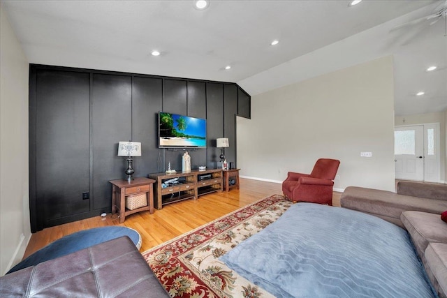 living room featuring light wood finished floors, baseboards, recessed lighting, and vaulted ceiling