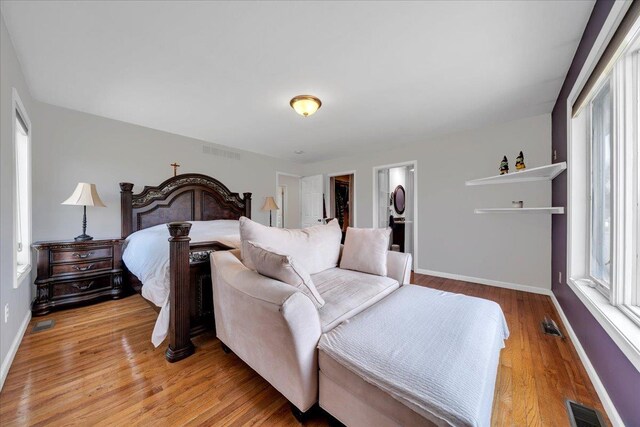 bedroom featuring light wood finished floors and baseboards