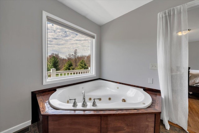 full bath with a whirlpool tub and vaulted ceiling