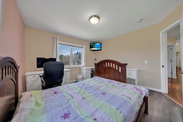 bedroom featuring wood finished floors and baseboards