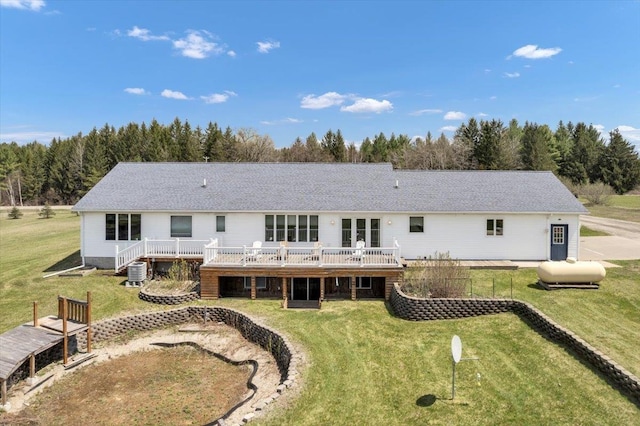 rear view of house with a wooden deck, a yard, and central AC