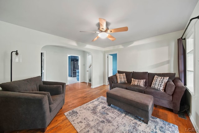 1107 Sunset Dr, Tecumseh, MI 49286 - living area featuring arched walkways, a ceiling fan, wood finished floors, and baseboards
