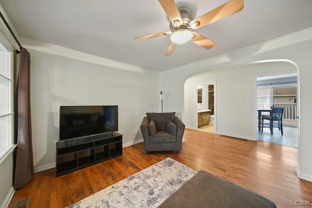 1107 Sunset Dr, Tecumseh, MI 49286 - living area featuring arched walkways, ceiling fan, and wood finished floors