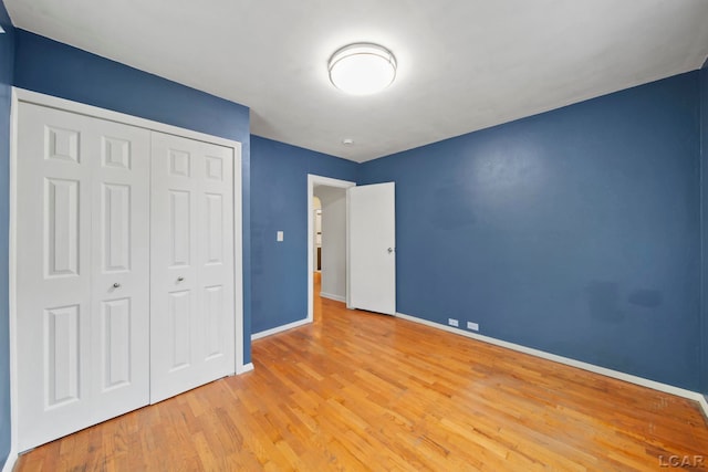 1107 Sunset Dr, Tecumseh, MI 49286 - unfurnished bedroom featuring baseboards, wood finished floors, and a closet