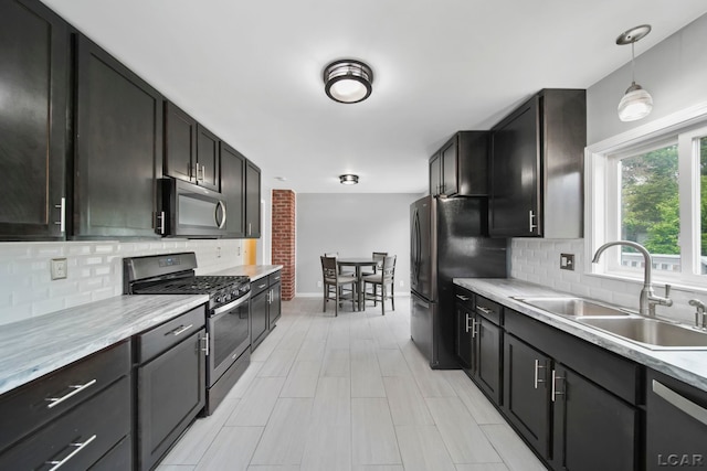 1107 Sunset Dr, Tecumseh, MI 49286 - kitchen featuring appliances with stainless steel finishes, a sink, light countertops, and backsplash